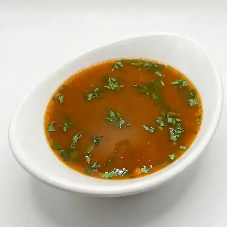 Miriyala Rasam — is a spicy South Indian soup with Black Pepper, Tamarind, and aromatic at Konaseema Cuisine, North Brunswick