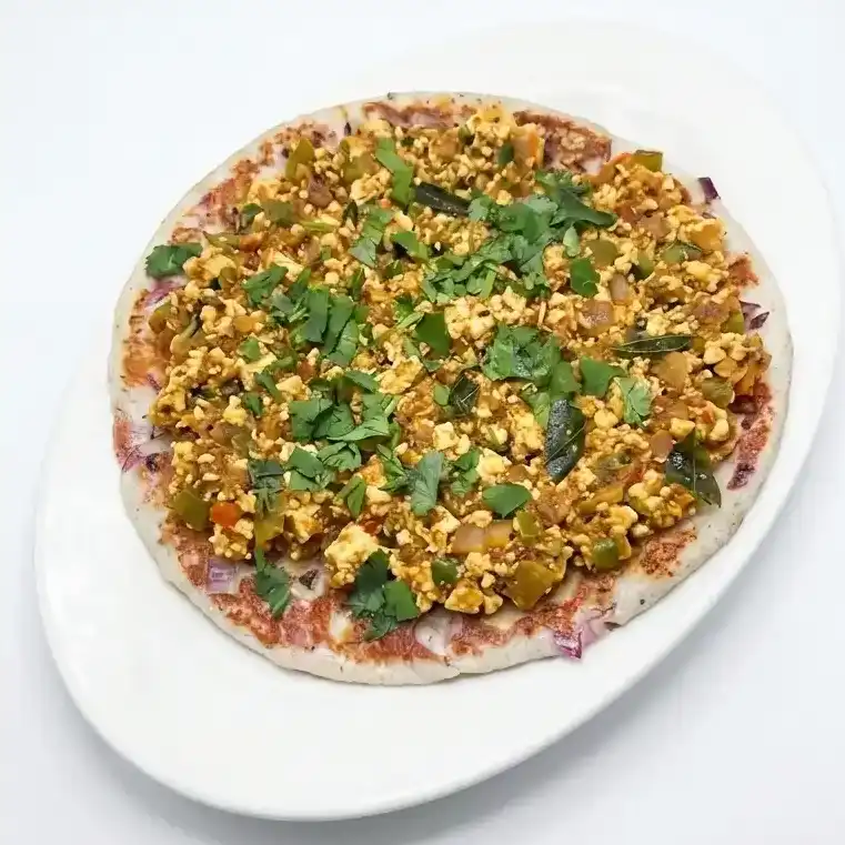 Paneer Burji Uthapam — Fluffy Indian pancake made with rice and lentil topped with grated at Konaseema Cuisine, North Brunswick