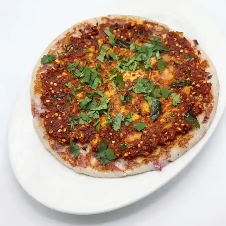 Andhara Spicy Uthappam — Fluffy Indian pancake made with rice and lentil topped with onions at Konaseema Cuisine, North Brunswick